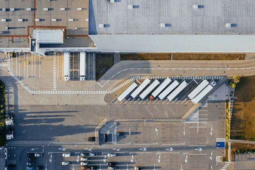 Overhead view of trucks parked in warehouse yard.